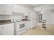 Functional kitchen featuring white appliances, laminate countertops, and a breakfast bar with storage shelves at 512 S Mebane St, Burlington, NC 27215