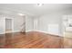 Open living room with hardwood floors, showcasing the staircase and a seamless flow to other living spaces at 512 S Mebane St, Burlington, NC 27215