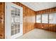 Enclosed sunroom boasts wood paneled walls and many windows at 512 S Mebane St, Burlington, NC 27215