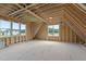 Unfinished attic space with windows, roof beams, and plywood floor at 5705 Flowery Meadow Ct, Wake Forest, NC 27587