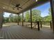 Spacious outdoor deck with a ceiling fan and wooden railings overlooking a treed lawn at 5705 Flowery Meadow Ct, Wake Forest, NC 27587