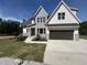 Charming two-story home featuring light gray brick, dark garage door and beautifully landscaped front yard at 5705 Flowery Meadow Ct, Wake Forest, NC 27587