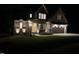 Charming home with brick accents, a modern garage door, and a patterned concrete driveway at night at 5705 Flowery Meadow Ct, Wake Forest, NC 27587