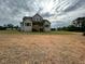 View of the back of a gray home with a spacious backyard and wooden deck at 5705 Flowery Meadow Ct, Wake Forest, NC 27587