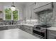 Modern kitchen with gray cabinets, stainless steel appliances, white countertops, and stylish tile backsplash at 5705 Flowery Meadow Ct, Wake Forest, NC 27587