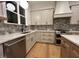 Modern kitchen with gray cabinets, hexagon backsplash, stainless steel appliances, and hardwood floors at 5705 Flowery Meadow Ct, Wake Forest, NC 27587