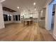 Spacious kitchen flowing into living area with hardwood floors, white cabinets, and stylish chandeliers at 5705 Flowery Meadow Ct, Wake Forest, NC 27587