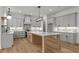 Spacious kitchen with gray cabinets, a kitchen island, modern appliances, tile backsplash and hardwood floors at 5705 Flowery Meadow Ct, Wake Forest, NC 27587