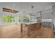 Spacious kitchen with gray cabinets, a kitchen island, modern appliances, and hardwood floors at 5705 Flowery Meadow Ct, Wake Forest, NC 27587