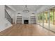 Bright living room featuring hardwood floors, built-in shelves, a fireplace and sliding doors to the outdoors at 5705 Flowery Meadow Ct, Wake Forest, NC 27587