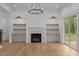 Bright living room featuring hardwood floors, built-in shelves, a fireplace and sliding doors to the outdoors at 5705 Flowery Meadow Ct, Wake Forest, NC 27587