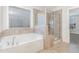 This bathroom features tiled walls, a glass enclosed shower and a separate soaking tub at 58 Atkins Village Ct, Fuquay Varina, NC 27526
