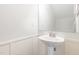 Bathroom featuring pedestal sink with framed mirror and white wainscoting at 58 Atkins Village Ct, Fuquay Varina, NC 27526
