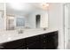 Bright bathroom features a double sink vanity with dark cabinets and a large mirror at 58 Atkins Village Ct, Fuquay Varina, NC 27526