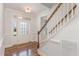 Bright foyer with hardwood floors features a staircase and a glass-paneled front door offering natural light at 58 Atkins Village Ct, Fuquay Varina, NC 27526