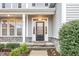 Inviting front entrance featuring a decorative glass door, stone accents, and a cozy covered porch with columns at 58 Atkins Village Ct Ct, Fuquay Varina, NC 27526