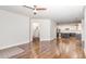 Open-concept living space with hardwood floors, a view of the foyer staircase, and a modern kitchen at 58 Atkins Village Ct, Fuquay Varina, NC 27526