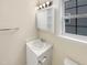 Bright bathroom boasts a vanity with storage, medicine cabinet, and a window at 5803 Osprey Cove Dr, Raleigh, NC 27604