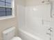 Clean white bathtub with shower and a modern shower head near the bright window at 5803 Osprey Cove Dr, Raleigh, NC 27604