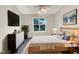 Bright bedroom featuring a bed with a white and tan bedspread, a large window and a television at 5803 Osprey Cove Dr, Raleigh, NC 27604