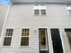 Two-story home featuring gray vinyl siding, double-hung windows, and a black front door at 5803 Osprey Cove Dr, Raleigh, NC 27604