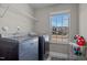 A bright laundry room features modern washer and dryer, storage shelves, and a well-lit window at 60 Sutherland Dr, Franklinton, NC 27525