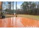 Large wooden deck overlooking a sprawling backyard with mature trees, offering a private retreat at 628 Stratford Dr, Zebulon, NC 27597