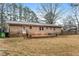 Lovely backyard view of the brick home with a wooden patio and lawn at 628 Stratford Dr, Zebulon, NC 27597