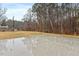 View of the backyard concrete patio in a spacious backyard, with trees in the background at 628 Stratford Dr, Zebulon, NC 27597
