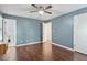 Spacious bedroom with wood floors, blue walls, and a ceiling fan, and access to an ensuite bath at 628 Stratford Dr, Zebulon, NC 27597
