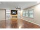 Bright living room with a ceiling fan, built-in shelves, and large windows at 628 Stratford Dr, Zebulon, NC 27597