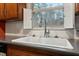 Close-up of a white porcelain kitchen sink with chrome faucet and leafy view at 628 Stratford Dr, Zebulon, NC 27597