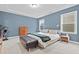Comfortable bedroom with blue walls, large windows, and modern furnishings at 6509 Archwood Ave, Raleigh, NC 27616
