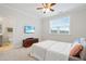 Well-lit bedroom with a ceiling fan, TV, and ensuite bathroom with a modern aesthetic at 6509 Archwood Ave, Raleigh, NC 27616