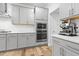 Well-lit kitchen featuring gray cabinets, stainless steel appliances, and subway tile backsplash at 6509 Archwood Ave, Raleigh, NC 27616