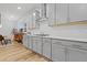 Bright kitchen featuring gray cabinets, stainless steel hood, and white quartz countertops at 6509 Archwood Ave, Raleigh, NC 27616