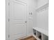 Mudroom area with coat hooks, a bench, and storage cubbies near a white door at 6509 Archwood Ave, Raleigh, NC 27616