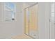 A glass-enclosed shower with tiled walls and a window at 6509 Archwood Ave, Raleigh, NC 27616