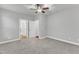 Neutral bedroom with gray carpet, a ceiling fan, and multiple doorways for easy access at 6509 Sunset Manor Dr, Wake Forest, NC 27587