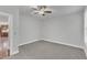 Neutral bedroom with gray carpet, a ceiling fan, and a view of the kitchen from the doorway at 6509 Sunset Manor Dr, Wake Forest, NC 27587