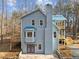 View of the house highlighting its architectural style, windows, and a section of the wooded backyard at 6817 Ramblewood Dr, Hillsborough, NC 27278