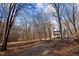 Home exterior featuring trees and a front yard with driveway at 6817 Ramblewood Dr, Hillsborough, NC 27278