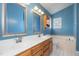 Well-lit bathroom with double sinks, vanity, and tile flooring at 8409 Astwell Ct, Raleigh, NC 27615