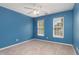 Bright blue bedroom with two windows and ceiling fan at 8409 Astwell Ct, Raleigh, NC 27615