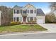 Charming two-story home featuring a well-manicured lawn, complemented by a red front door and black shutters at 8409 Astwell Ct, Raleigh, NC 27615