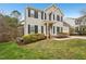 Charming home featuring a landscaped yard, complemented by a red front door and black shutters at 8409 Astwell Ct, Raleigh, NC 27615