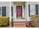 Welcoming front porch with red door, brick steps, and address number, creating a warm entry to the home at 8409 Astwell Ct, Raleigh, NC 27615