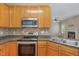 Well-lit kitchen with stainless steel appliances and wooden cabinets with an eat-in dining area at 8409 Astwell Ct, Raleigh, NC 27615