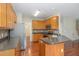 Well-lit kitchen featuring light wood cabinets, granite countertops, and stainless steel appliances at 8409 Astwell Ct, Raleigh, NC 27615