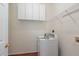 Functional laundry area with white cabinets, a utility sink, and a modern washing machine at 8409 Astwell Ct, Raleigh, NC 27615